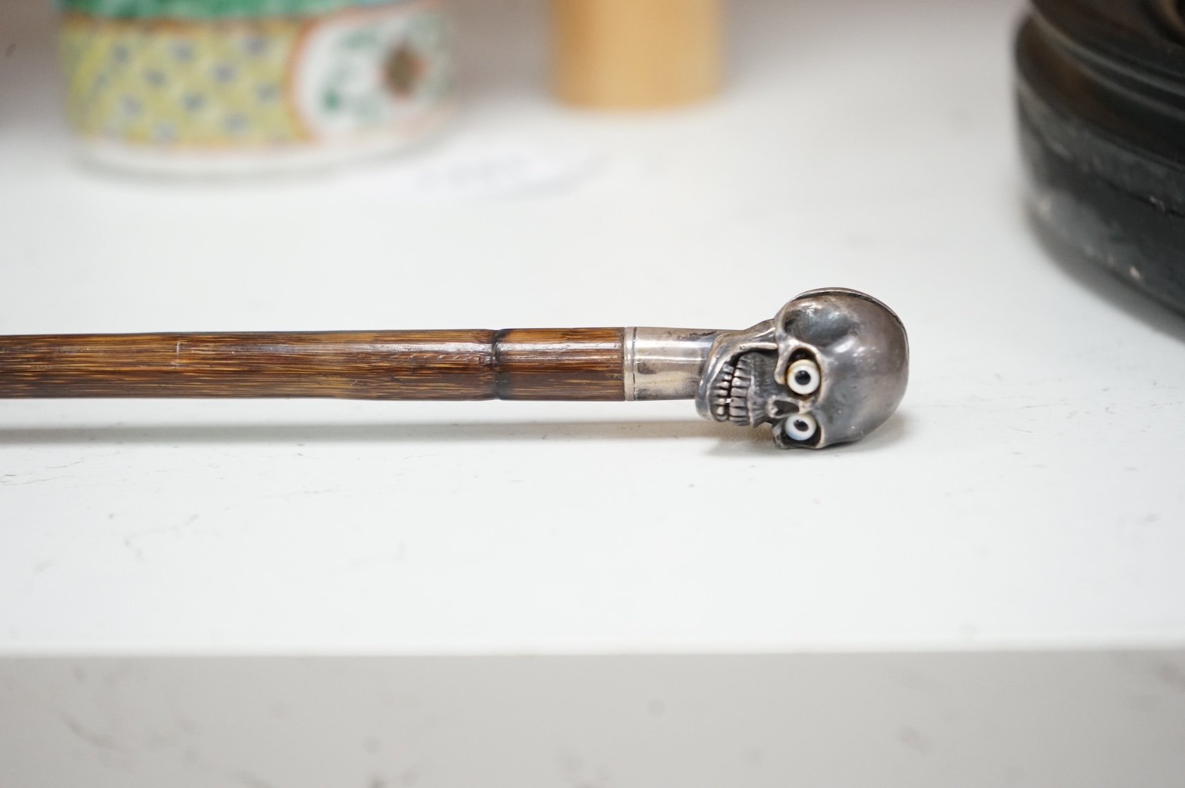 A 19th century bamboo walking stick with memento mori skull finial, the skull with articulated jaw, 84cm in length